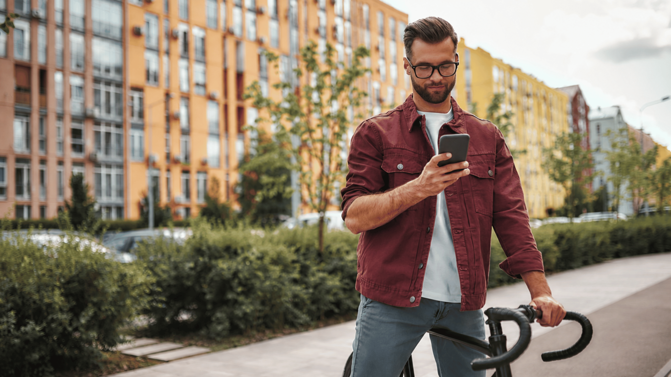 Man is on phone while holding bike still - Aven Hospitality